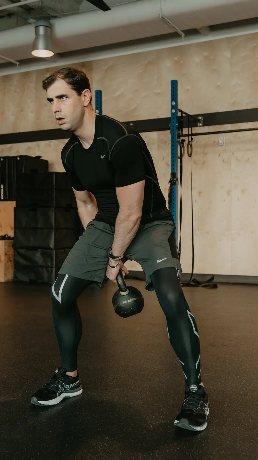 Nathan Brennan mid kettlebell swing in a training studio